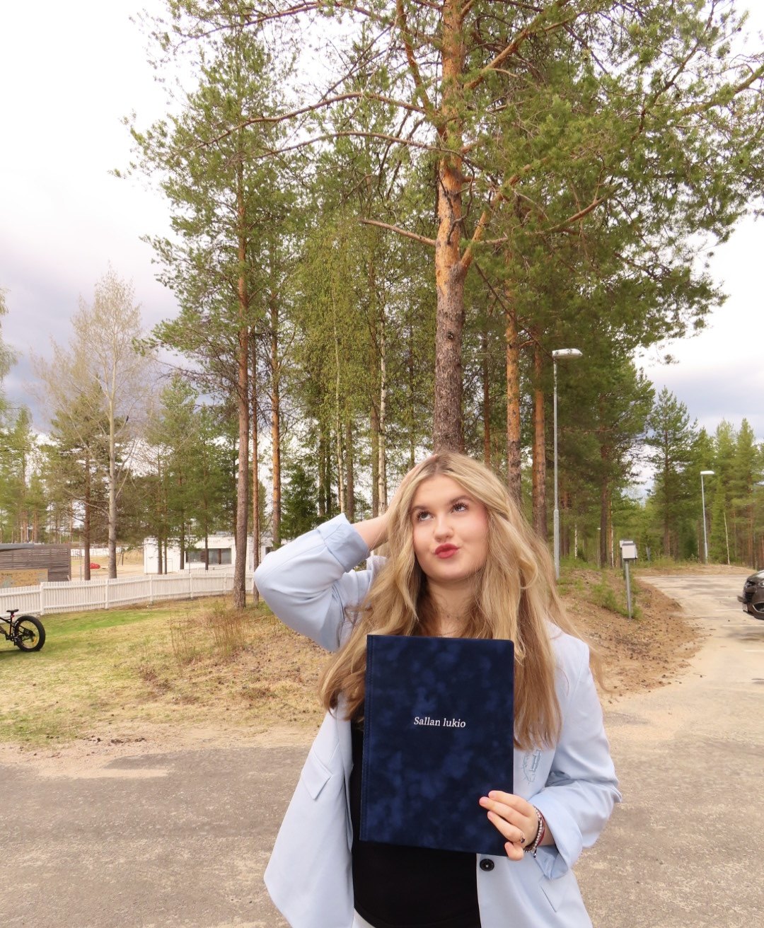 Portrait of Anastasiia Flikova holding a diploma folder